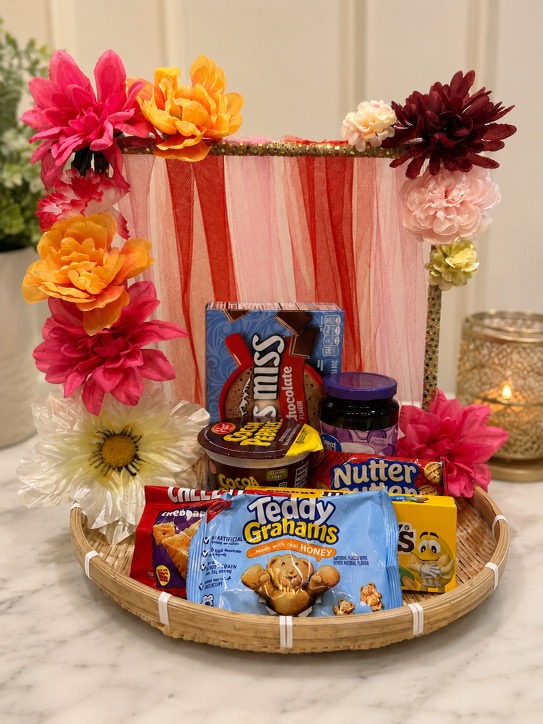 Gift basket with cookies, snacks, and floral decoration